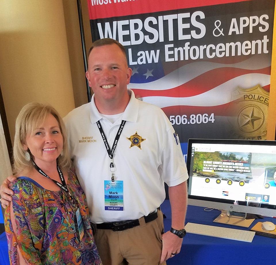 Renea and Sheriff Moon in front of trade show booth